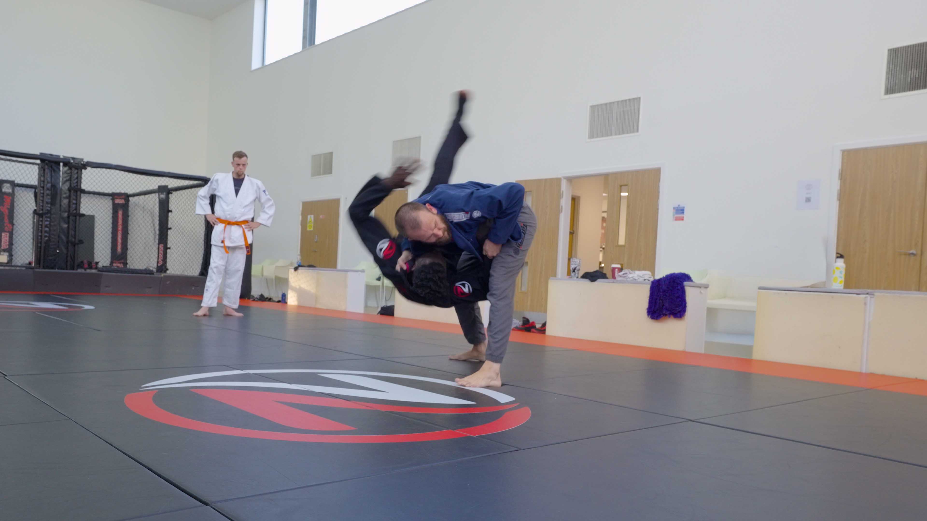 Judoka throwing a training partner mid-air during judo practice at Zilla Training